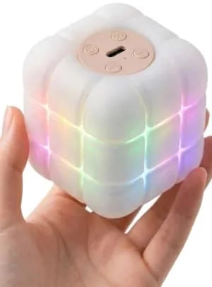 A hand holding the palm-sized cube, showing its soft silicone grid and the buttons on top
