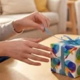 Two people handing over a wrapped gift box