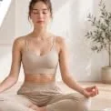 A woman meditating cross-legged on a yoga mat